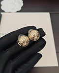 Round gold-tone stud earrings with ornate medallion faces