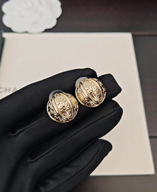 Round gold-tone stud earrings with ornate medallion faces