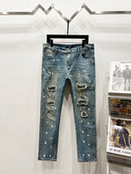 Light blue distressed denim jeans with rips and studded embellishments, straight leg