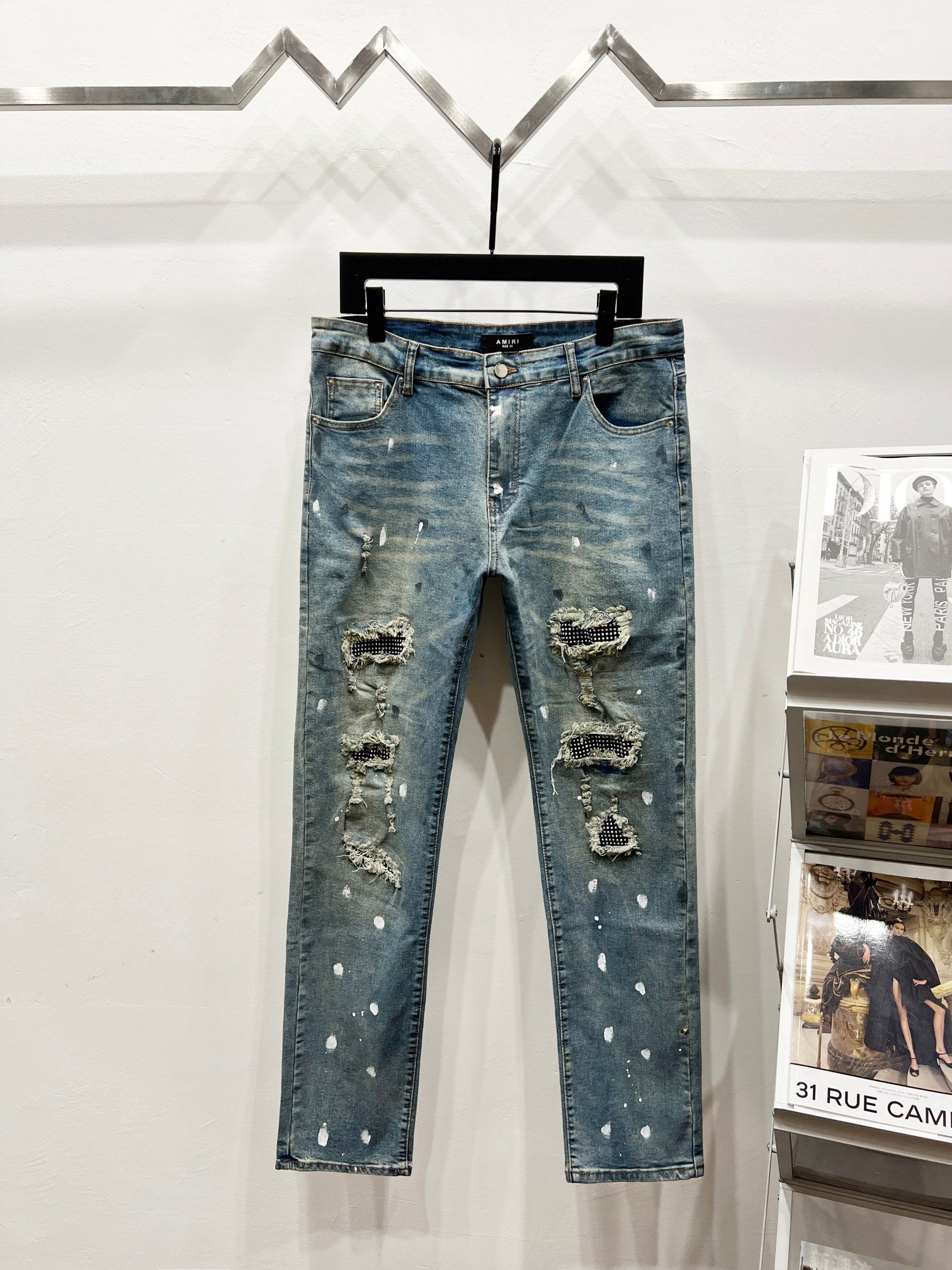 Light blue distressed denim jeans with rips and studded embellishments, straight leg