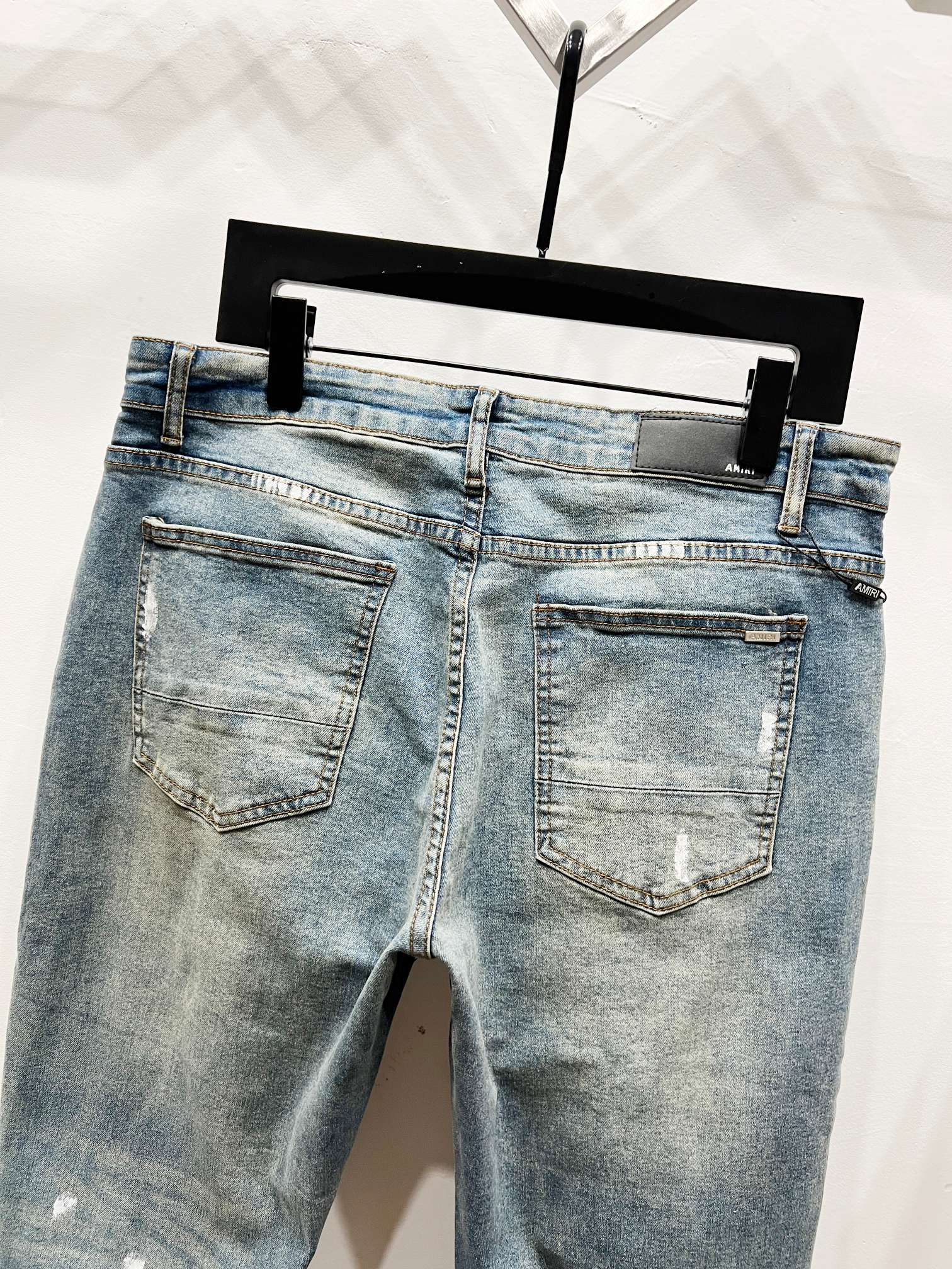 Light blue denim jeans back view with stitched pockets and subtle distressing