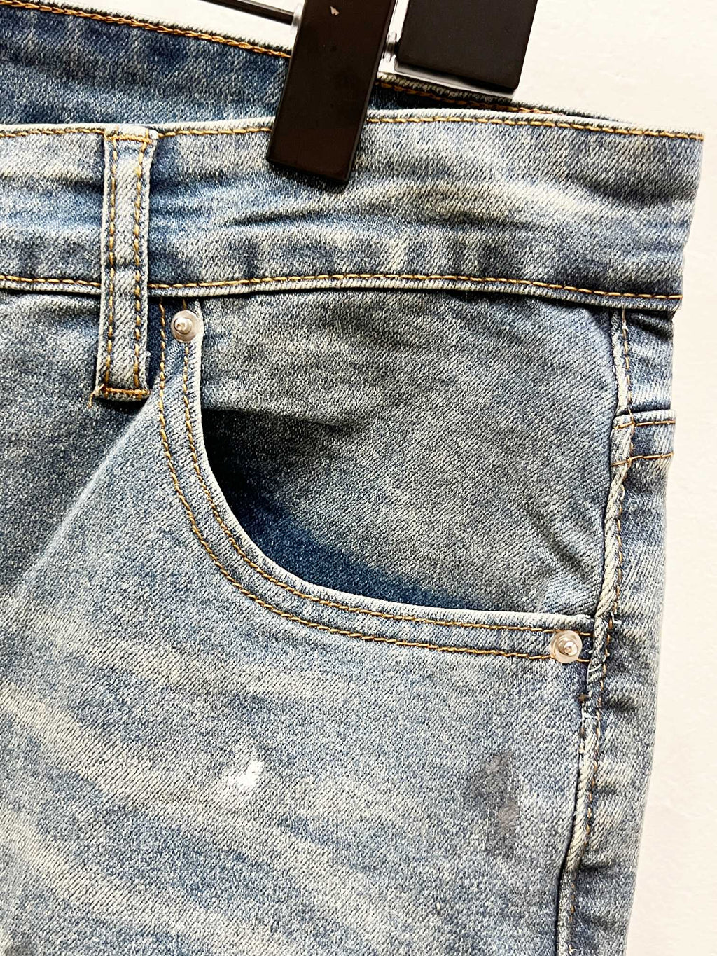 Light blue denim jeans front pocket with metal button and stitched waistband