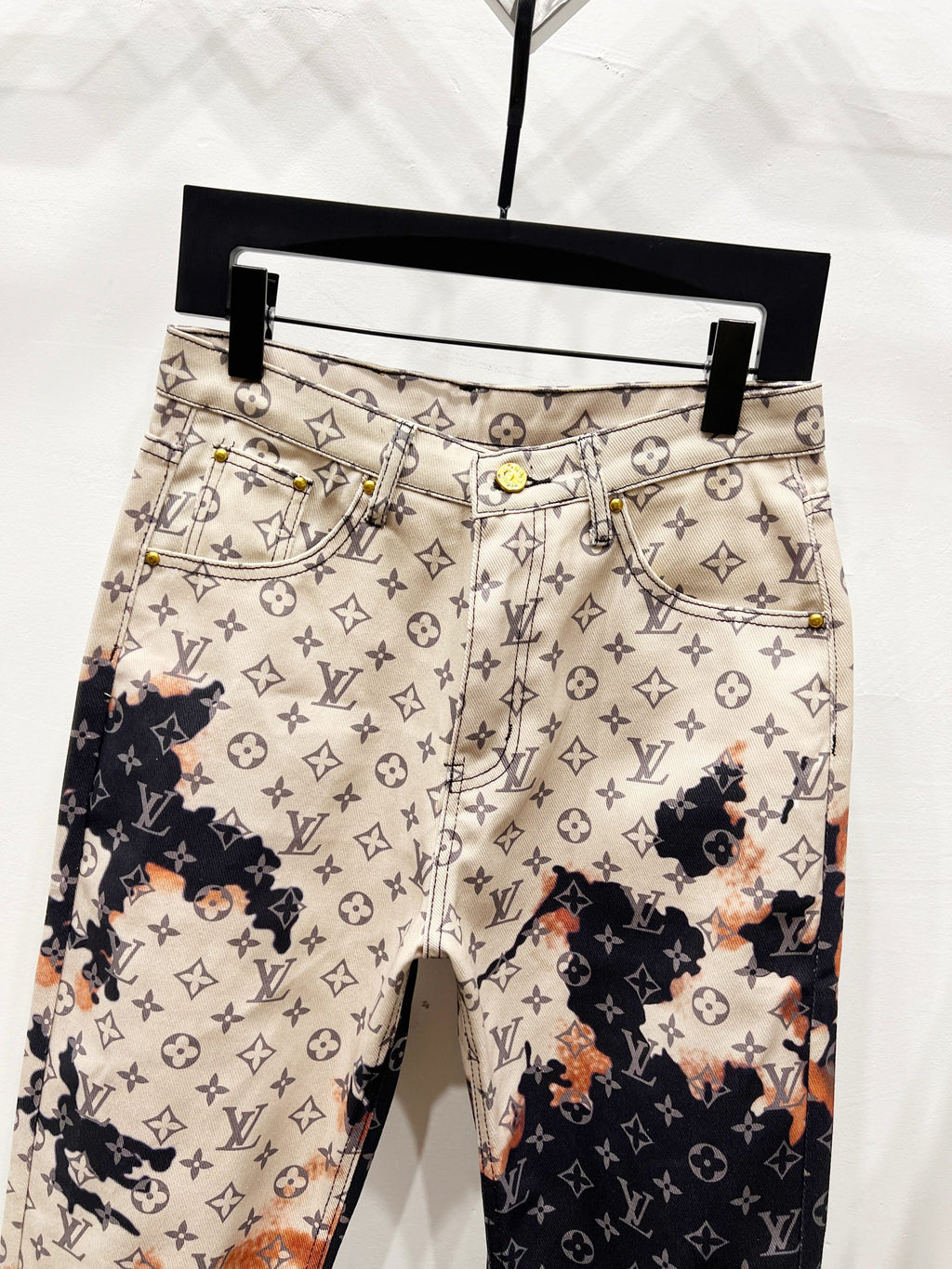 Monogram print trousers with beige waistband, front button, and side pockets