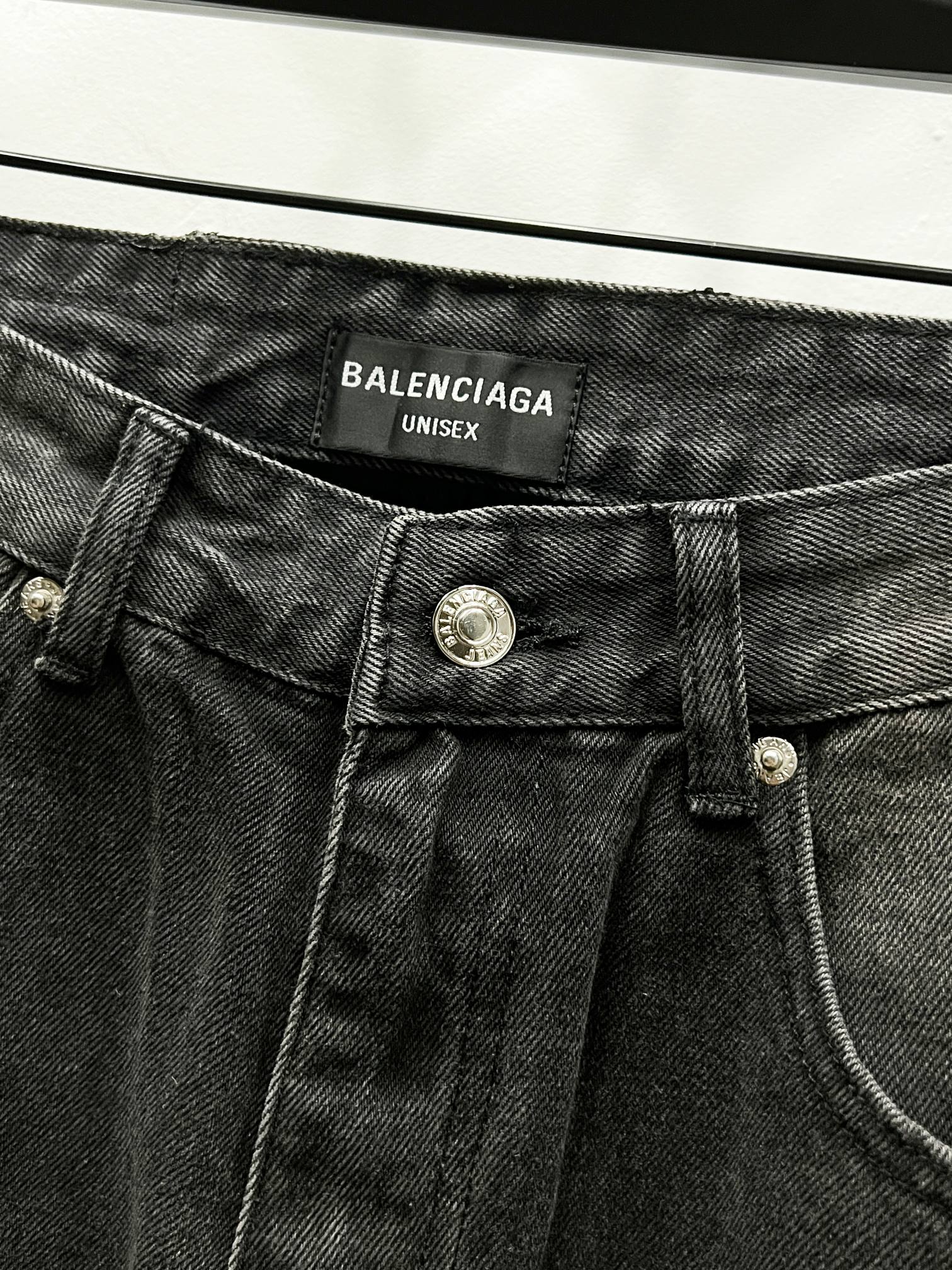 Dark denim waistband with Balenciaga Unisex label and metal button closure