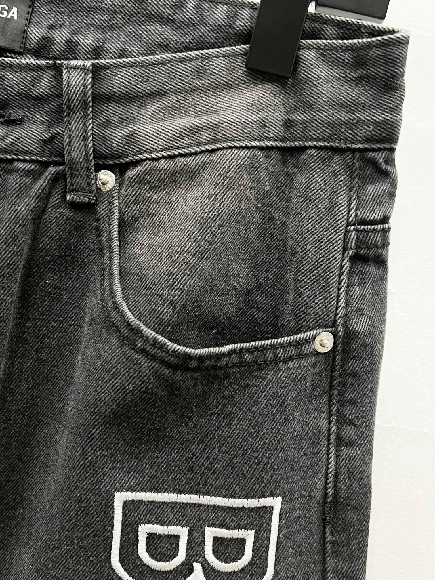 Dark denim front pocket with curved topstitching and Balenciaga logo print