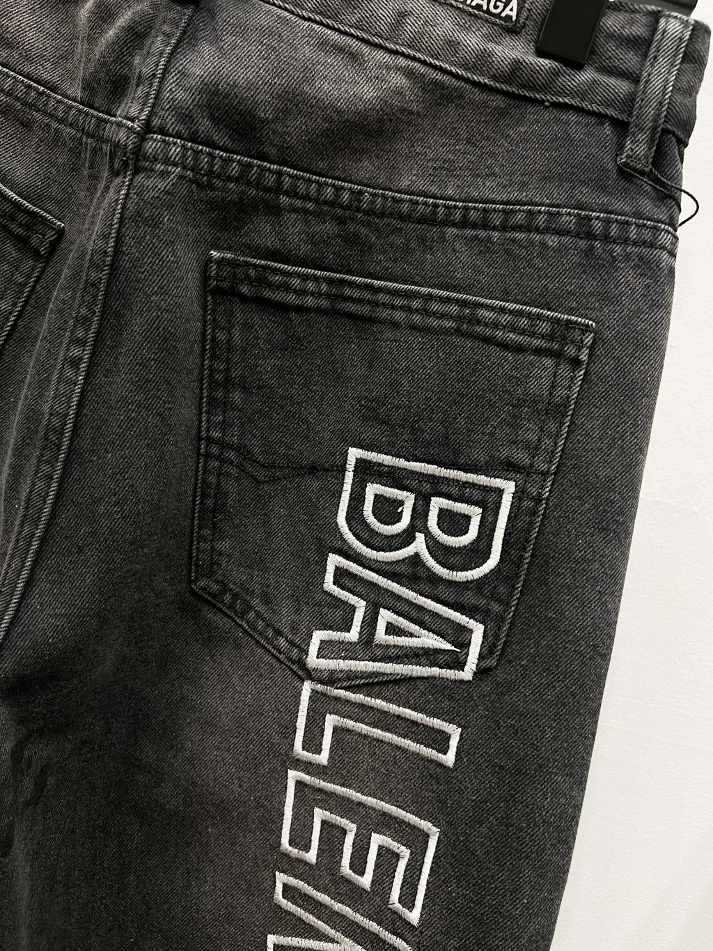Dark denim back pocket detail with Balenciaga logo patch print