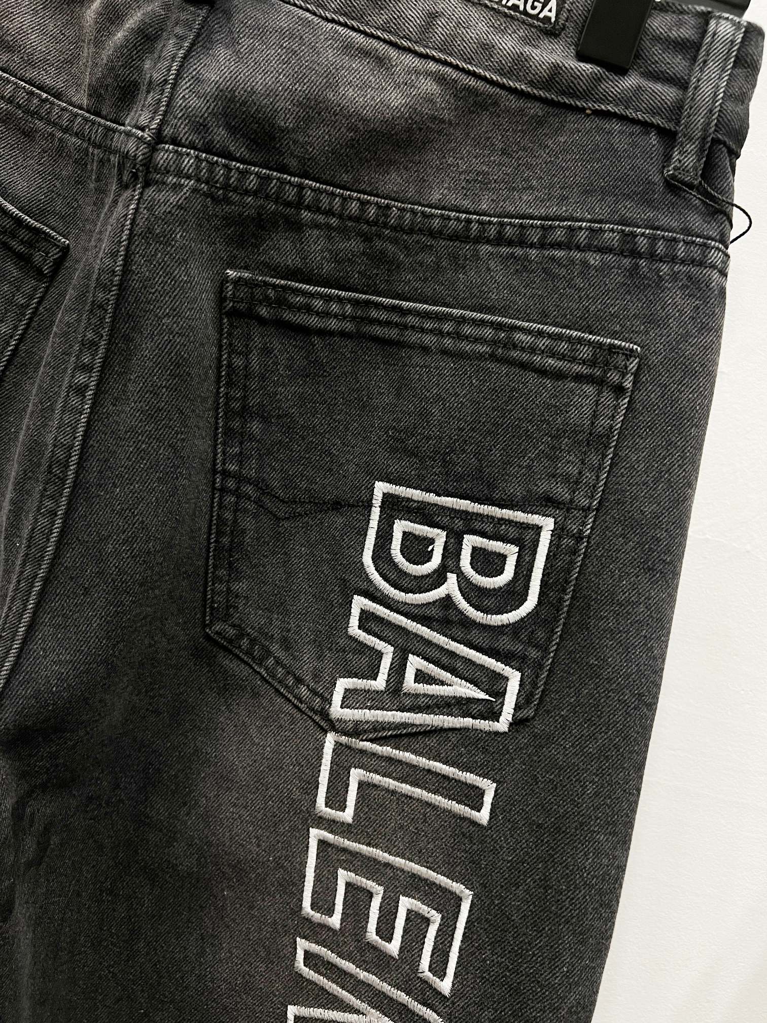 Dark denim back pocket detail with Balenciaga logo patch print