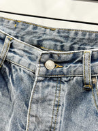 Light blue denim waistband close-up with metal button and belt loops