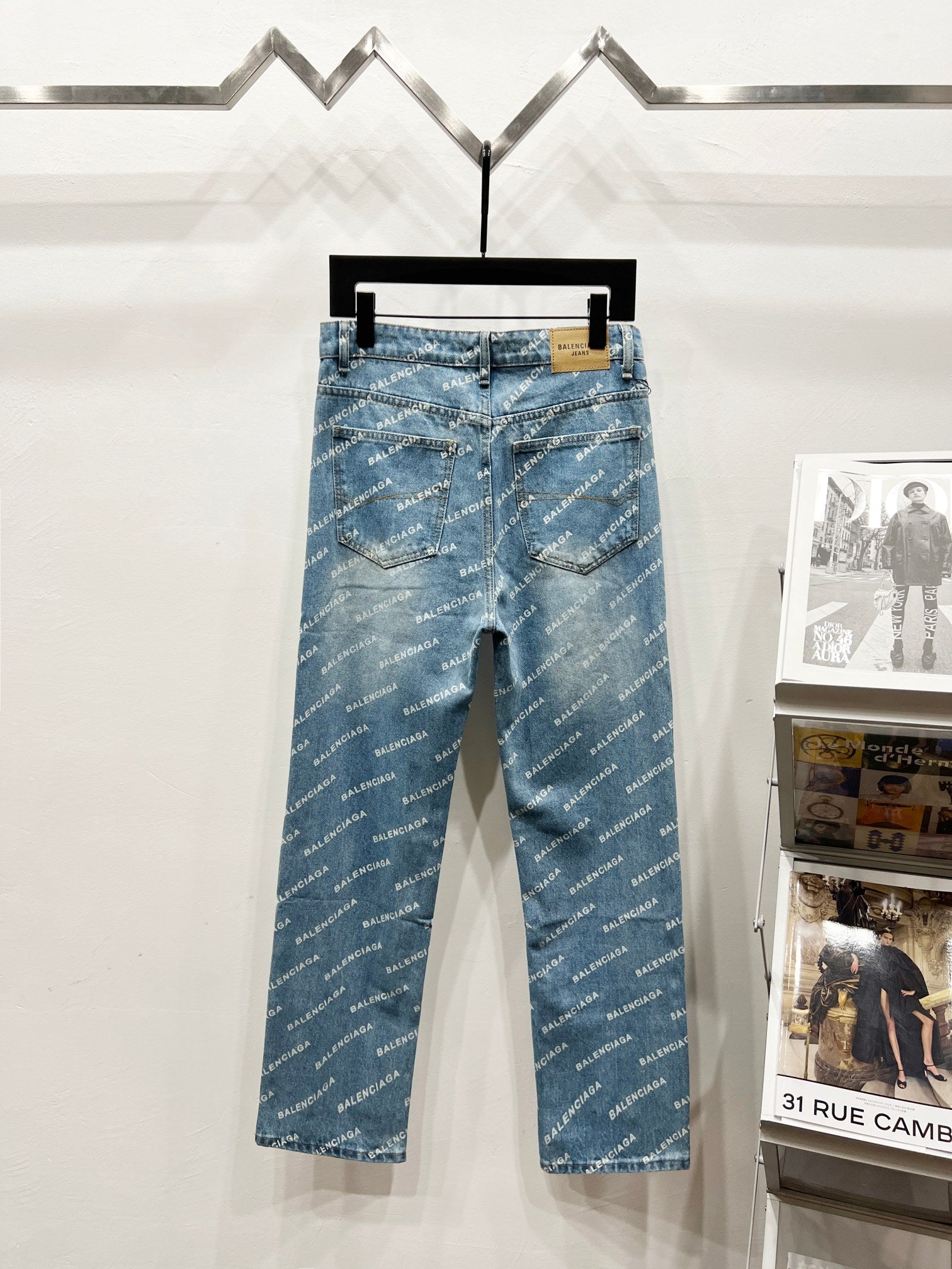 Blue denim pants with all-over logo print, zip fly, front pockets, and belt loops