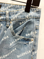 Front jean pocket close-up with logo print, metal button, and stitched seams