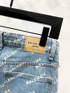 Denim jeans waistband close-up with tan patch label and stitched logo detailing