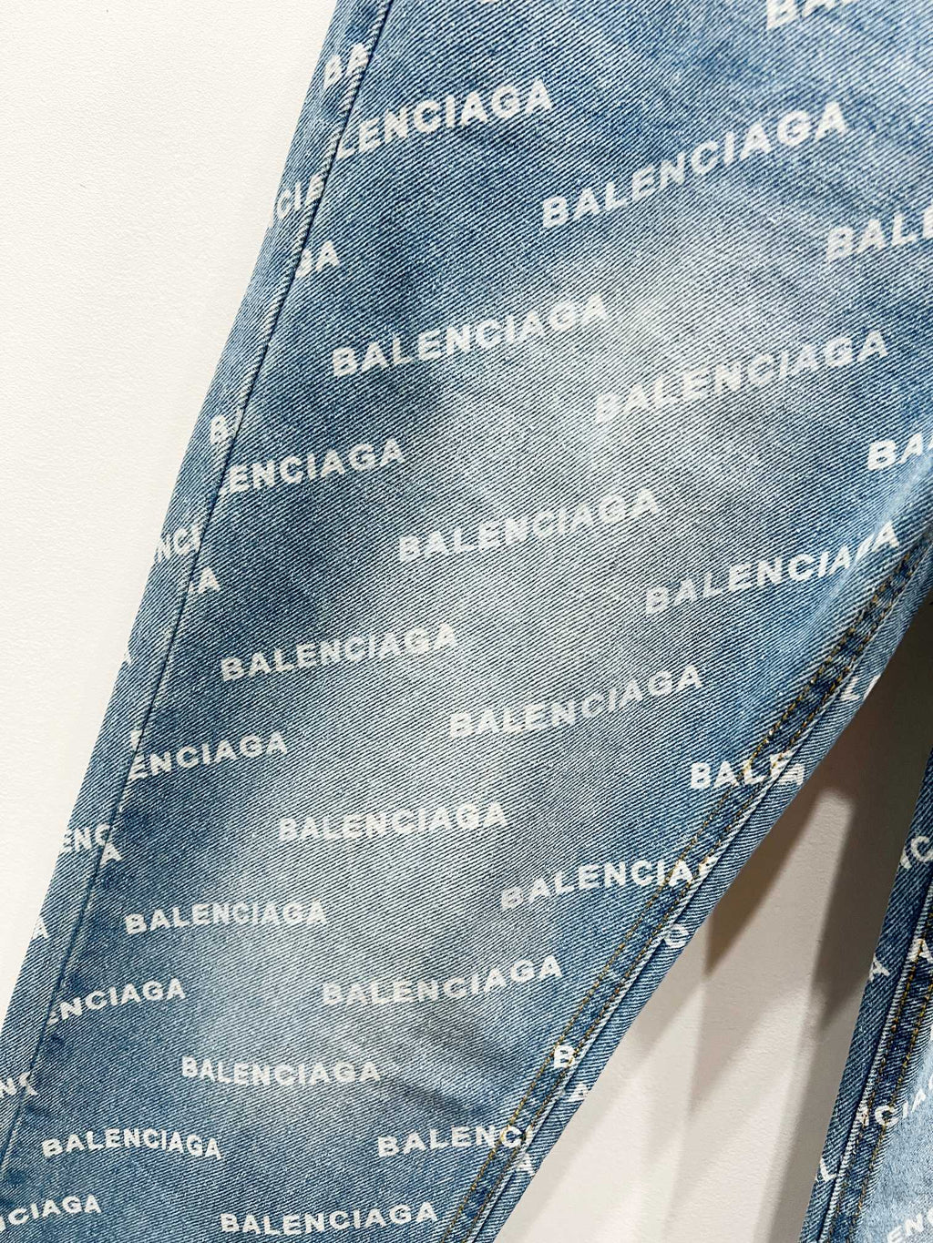 Light blue denim fabric with repeating BALENCIAGA logo pattern, diagonal texture