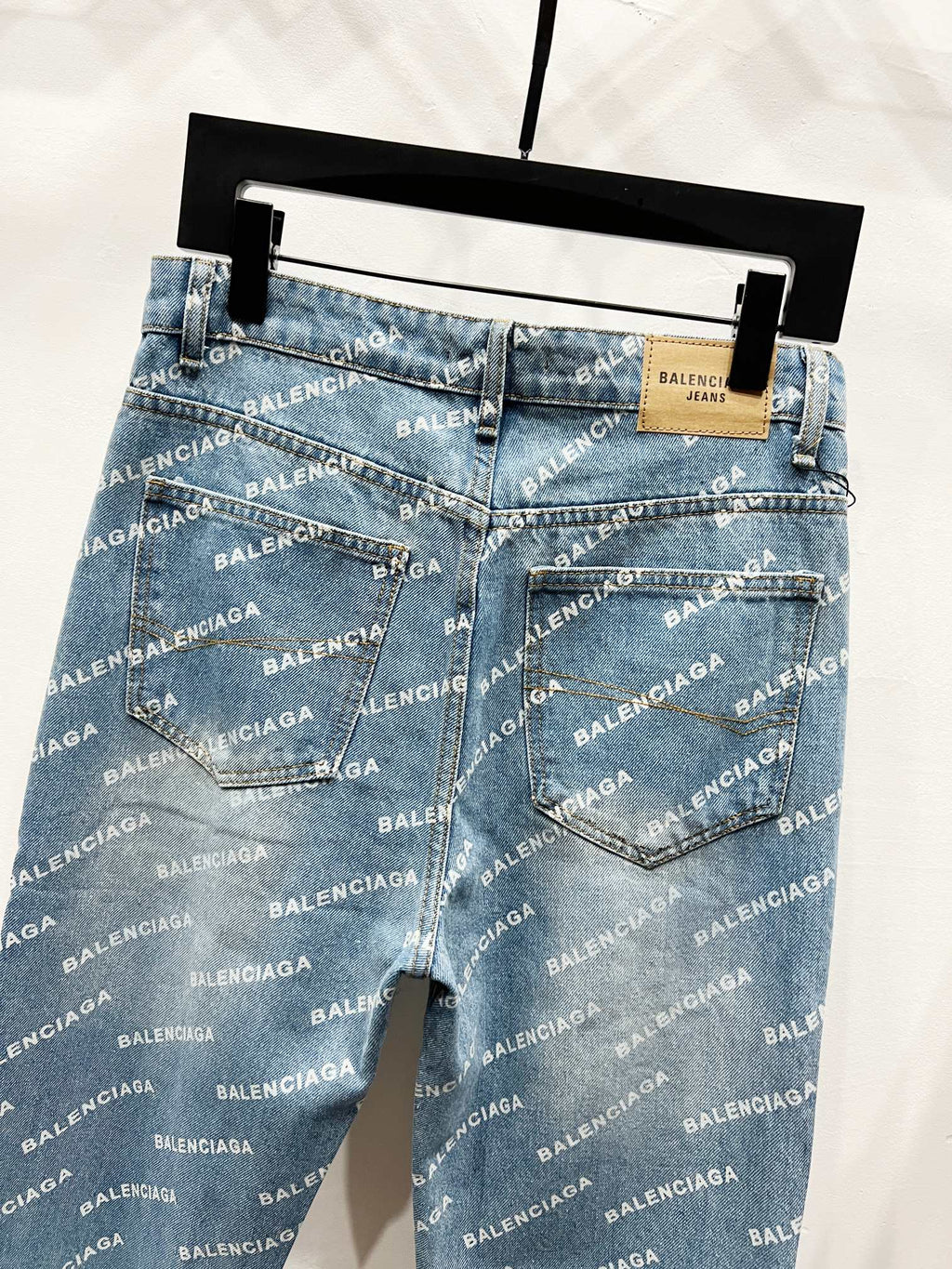 Blue logo-print denim pants front view with back darts and patch on waistband