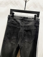 Black denim jeans with straight legs, front pockets, and waistband brand patch
