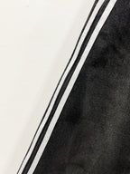 Black denim pants leg with contrasting side stripe along the seam
