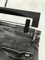 Black denim pants waistband with AMIRI label and belt loops, front seam detail