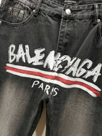 Black denim pants with Balenciaga graphic and red stripe, front close-up