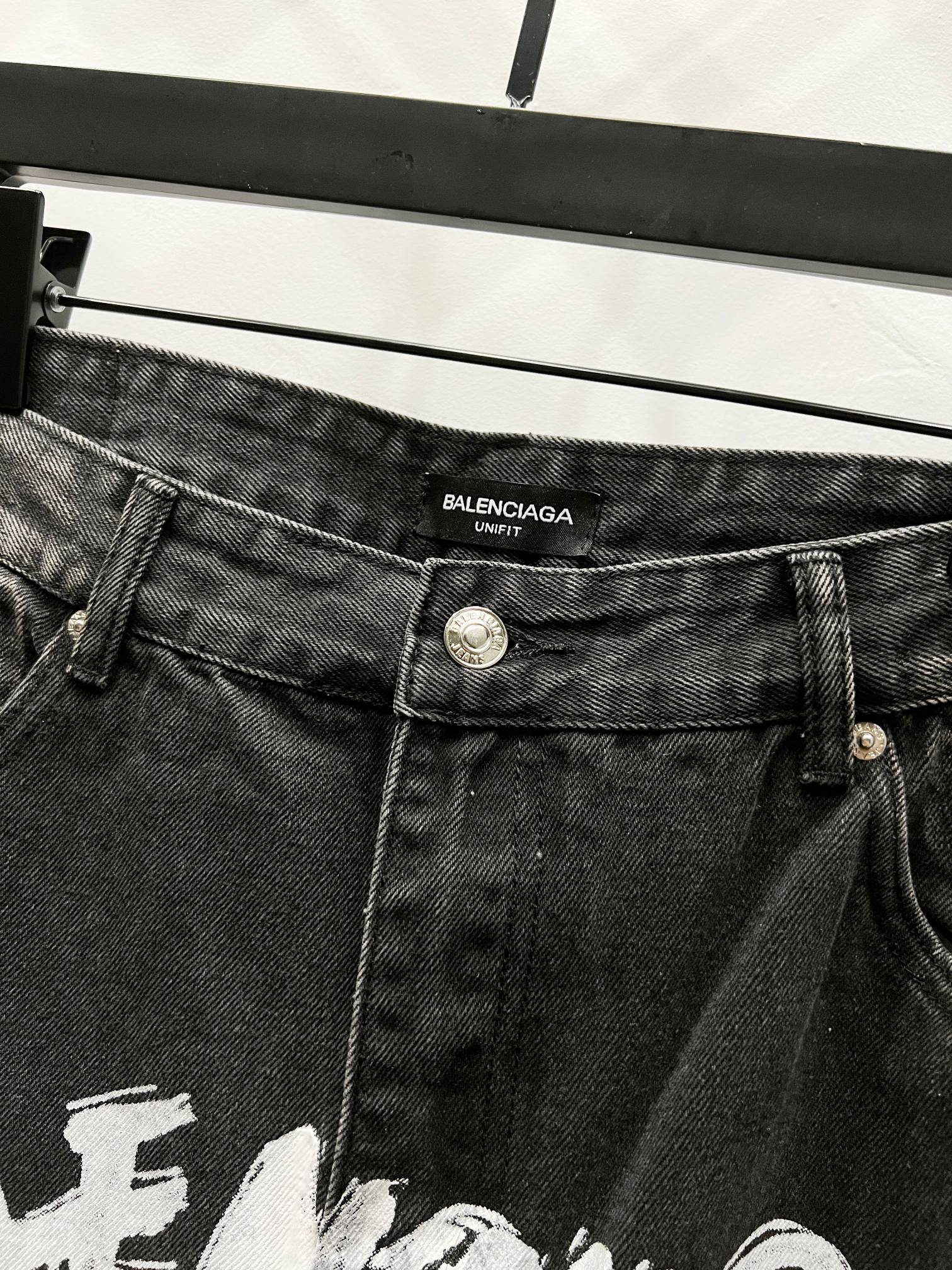 Black denim pants with Balenciaga label on waistband and metal button closure