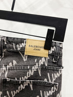 Black denim jeans with 'BALENCIAGA JEANS' leather patch on waistband and button fly