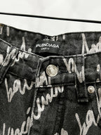Black denim jeans with Balenciaga Uniform label and metal button close-up