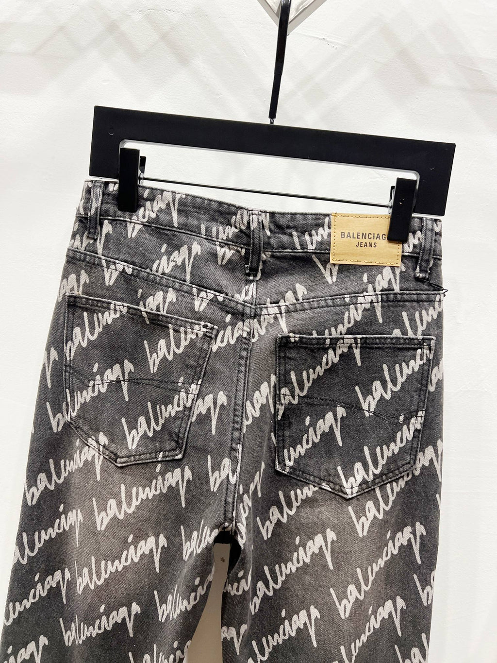 Black denim jeans with allover Balenciaga script print, front pockets and waistband label