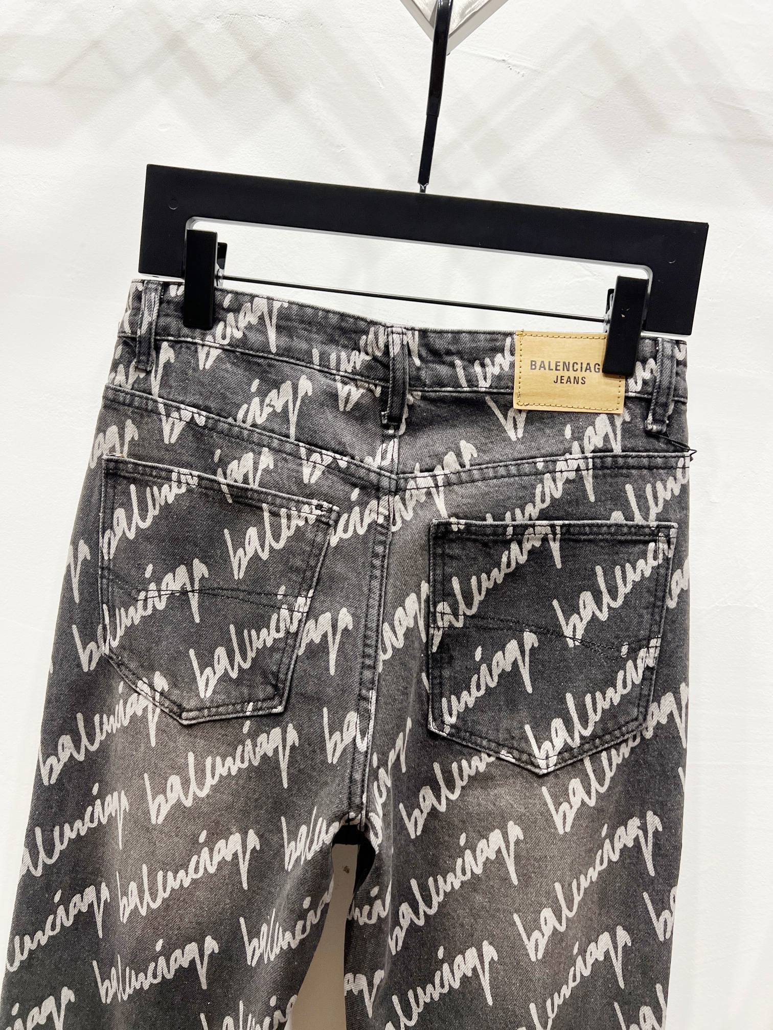 Black denim jeans with allover Balenciaga script print, front pockets and waistband label