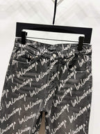 Black denim jeans with allover Balenciaga script print, front view with belt loops