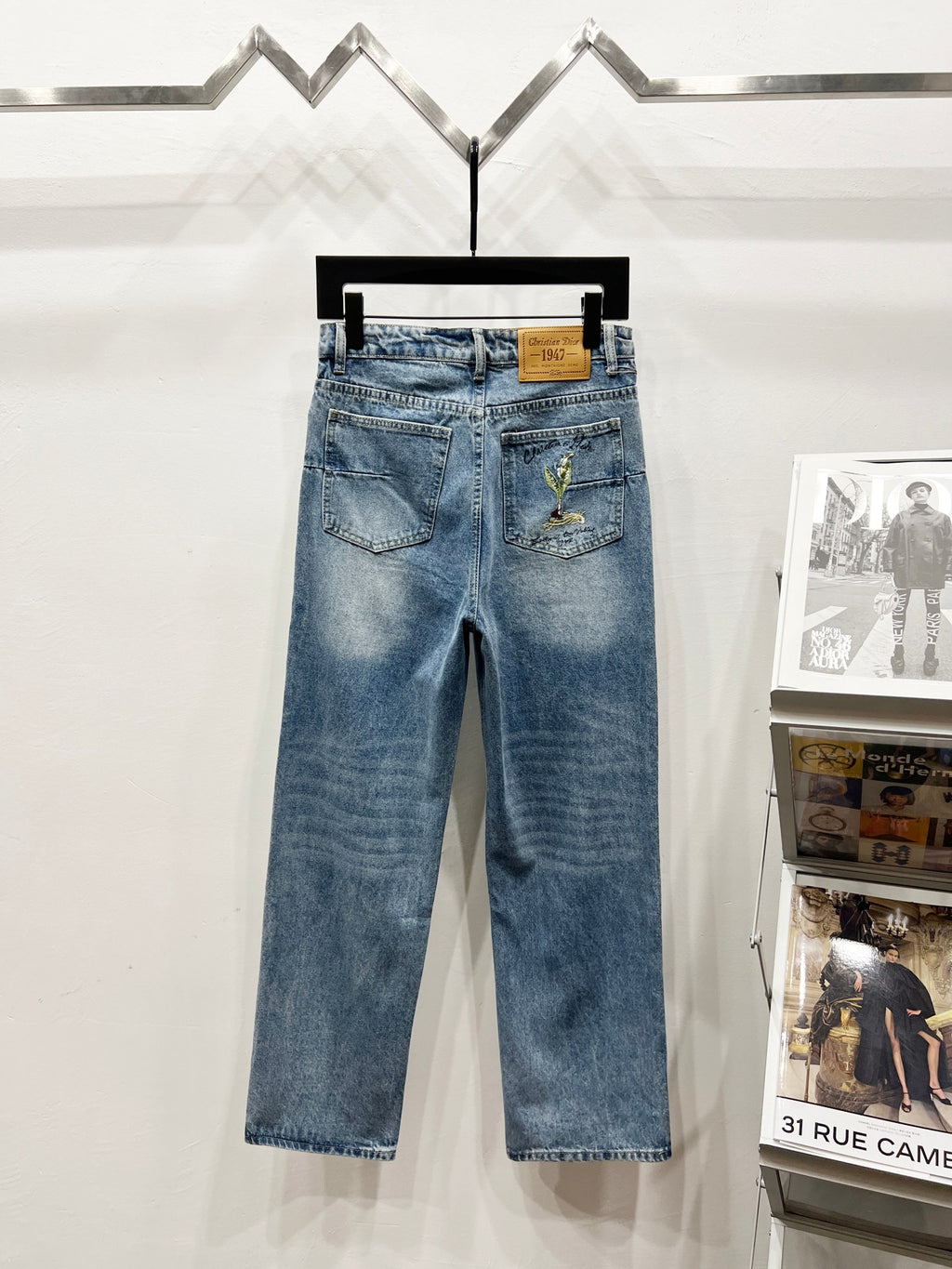 Light-wash denim pants with waist patch and green-gold floral embroidery