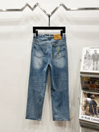 Light-wash denim pants with waist patch and green-gold floral embroidery