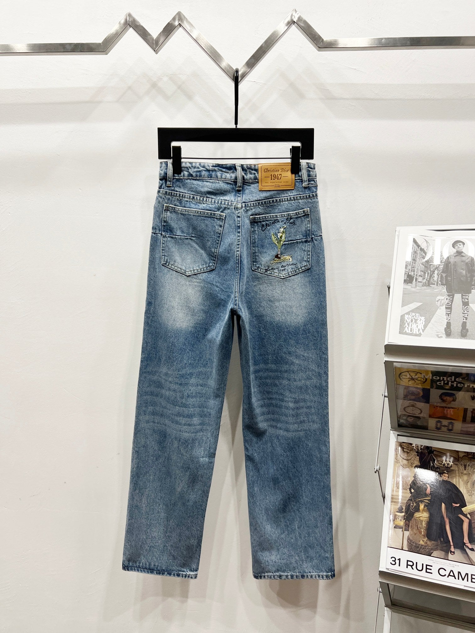 Light-wash denim pants with waist patch and green-gold floral embroidery