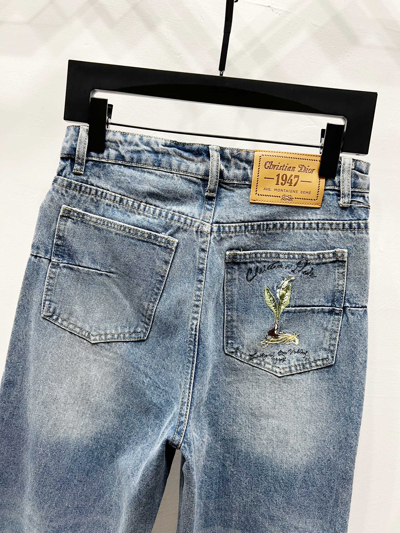 Light-wash denim pants, front view with pocket and tan brand patch