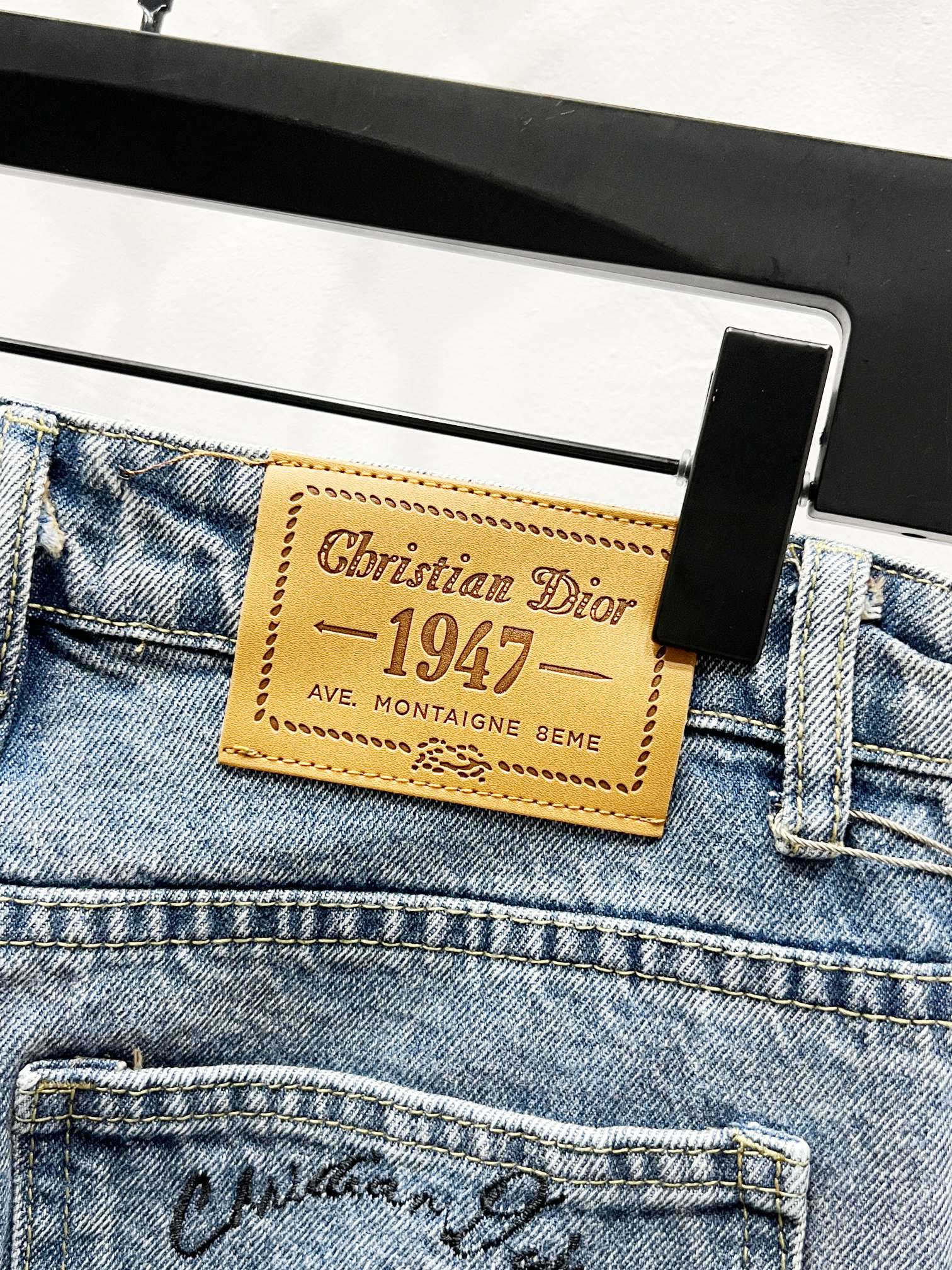 Light-wash denim pants with Christian Dior 1947 leatherette waist label