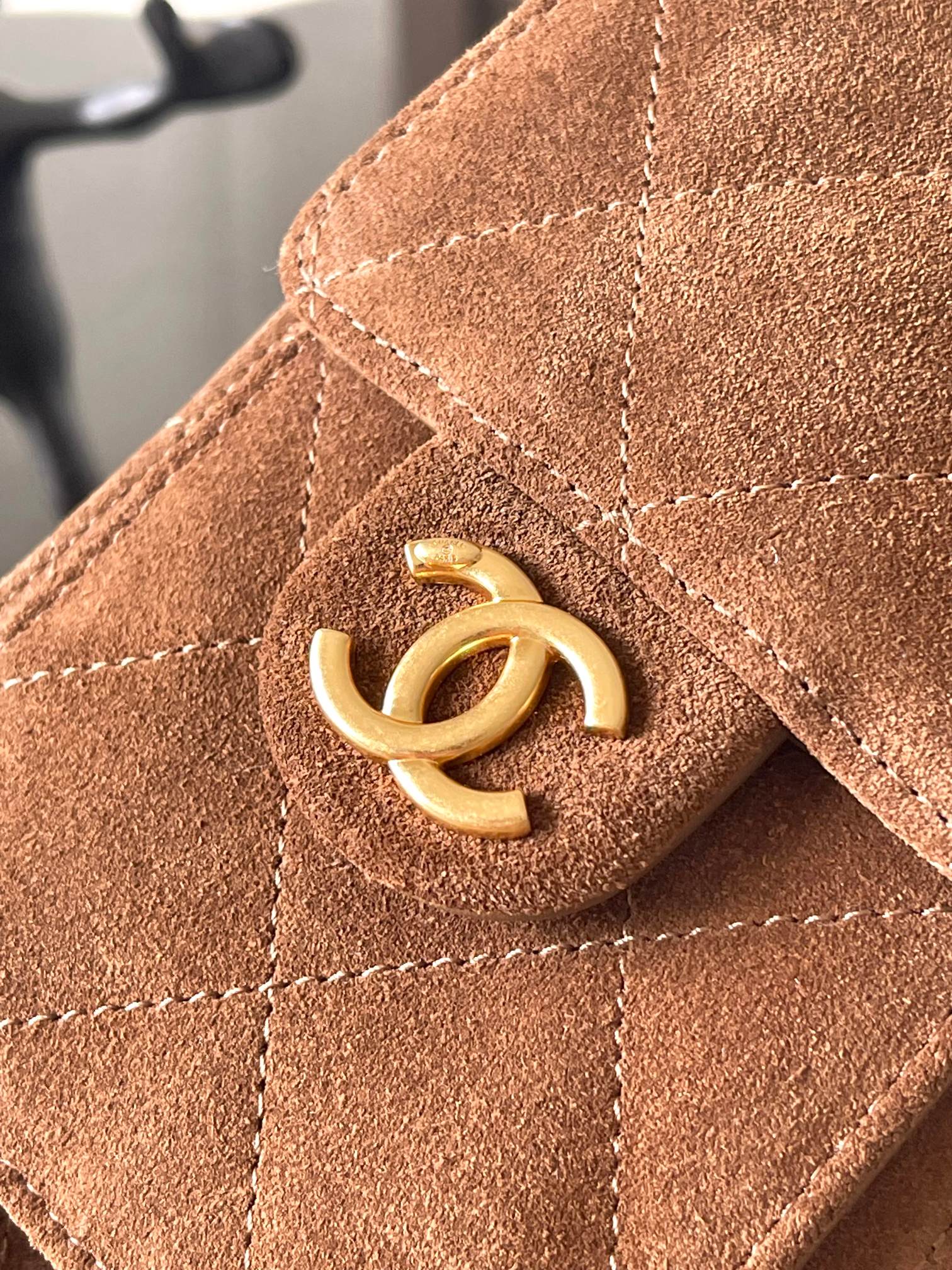 Gold loop detail on tan-brown suede bag flap