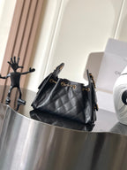Black Chanel quilted shoulder bag with gold chain strap and front clasp