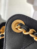 Black Chanel textured leather bag with gold clasp ring and chain attachment