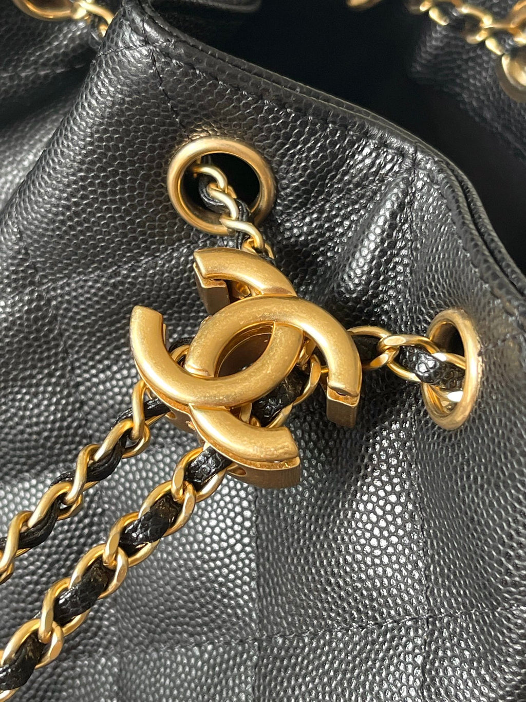 Gold-tone chain and ring hardware on black Chanel textured leather bag