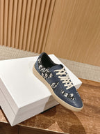 Navy blue low-top sneakers with white laces and abstract logo-style print