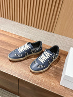 Navy blue low-top sneakers with white lace-up ties and patterned side panels