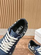 Navy blue low-top sneaker close-up with white laces and Dior text on the collar