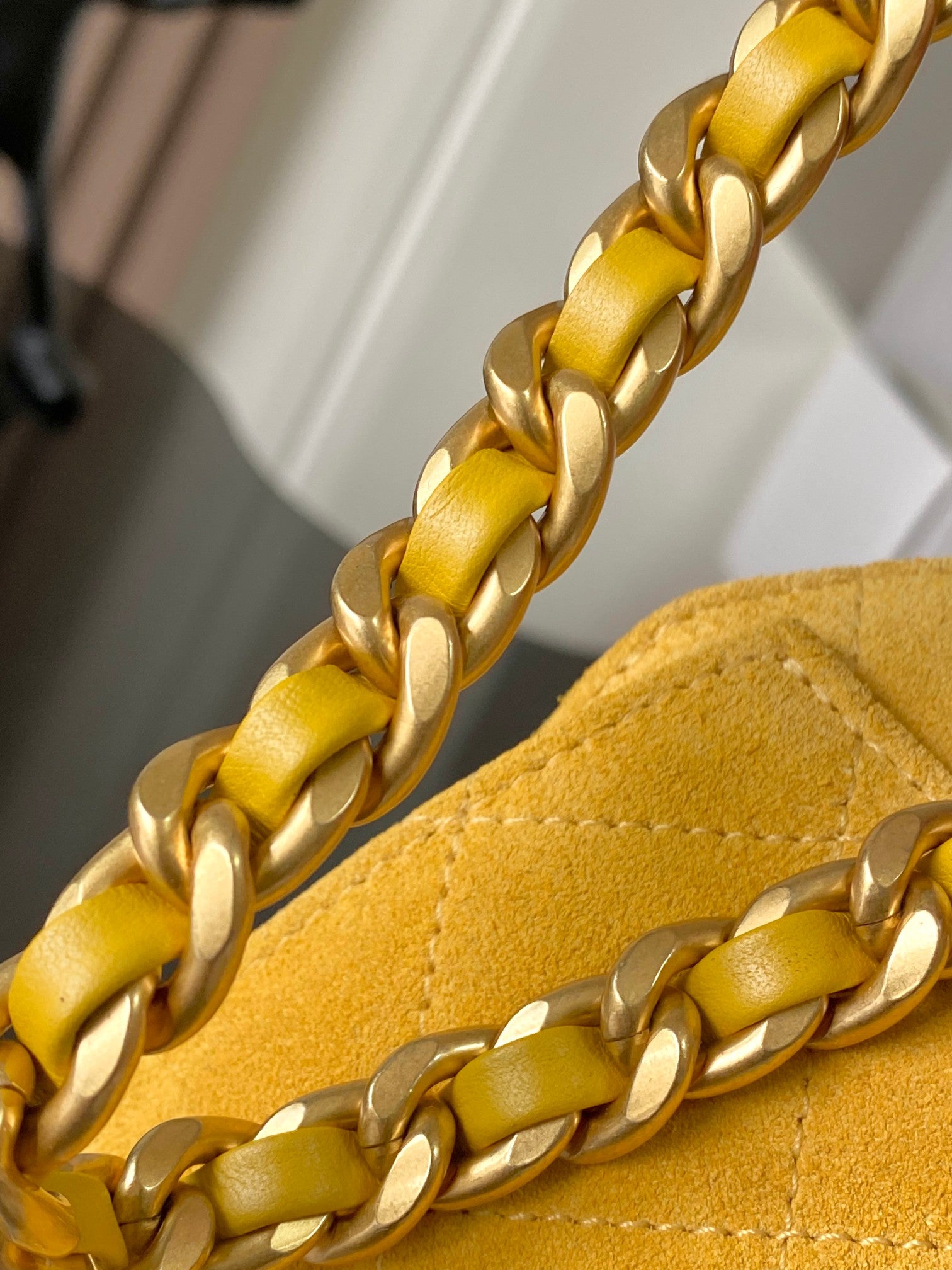 Chanel yellow chain strap close-up with linked gold hardware