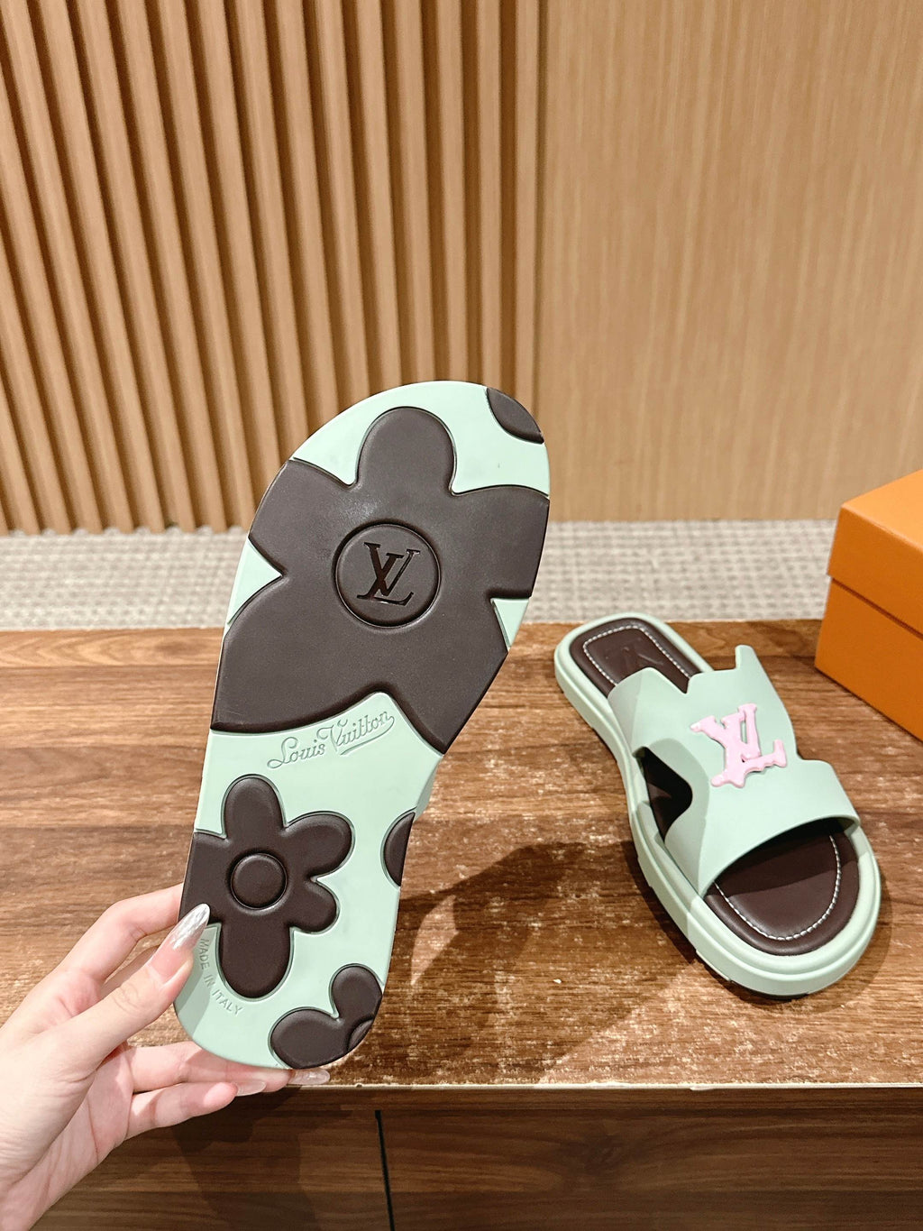 Louis Vuitton slide sandal outsole with flower motif beside mint slide sandal