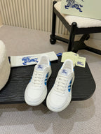 White sneakers with blue plaid side panels and logo, lace-up front view