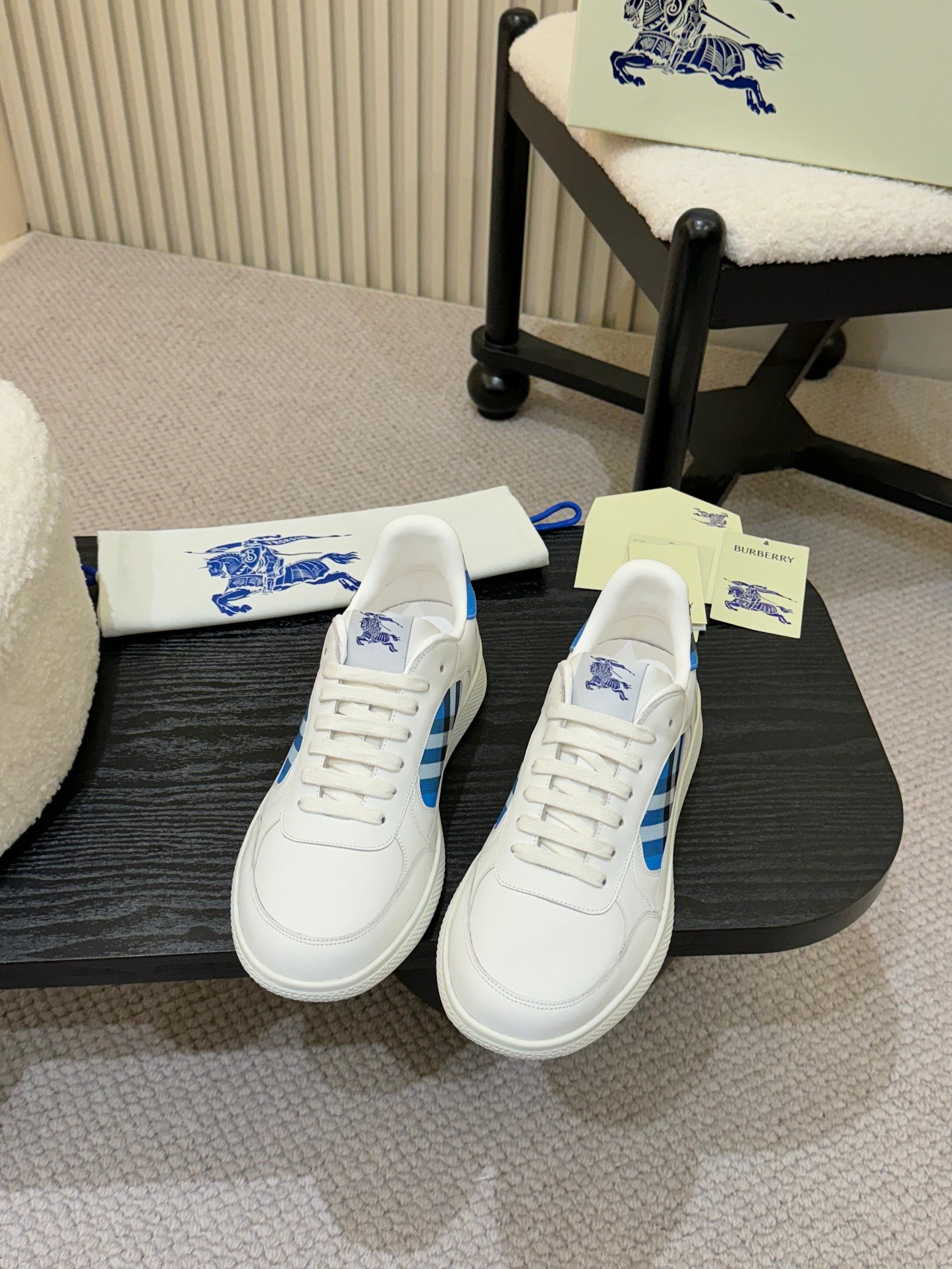 White sneakers with blue plaid side panels and logo, lace-up front view