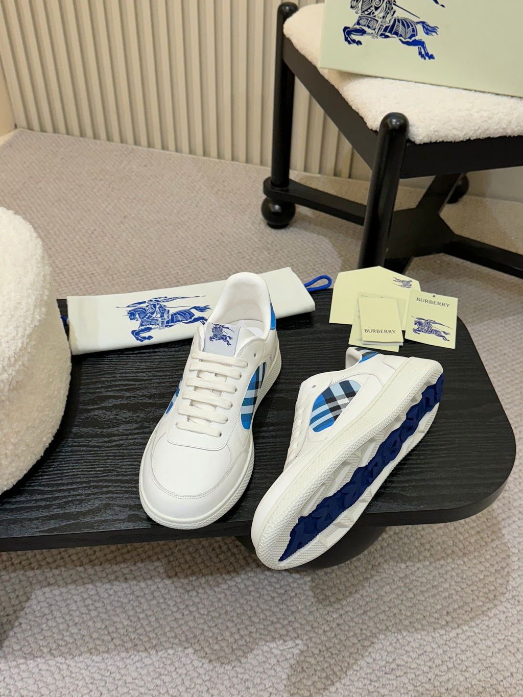 White sneakers with blue plaid heel and side details, angled view