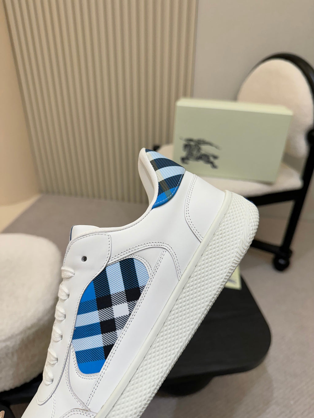 White sneaker side view with blue plaid panel and textured sole