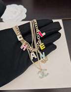 Gold-tone layered Chanel chain necklace with multicolor letter charms and CC pendant