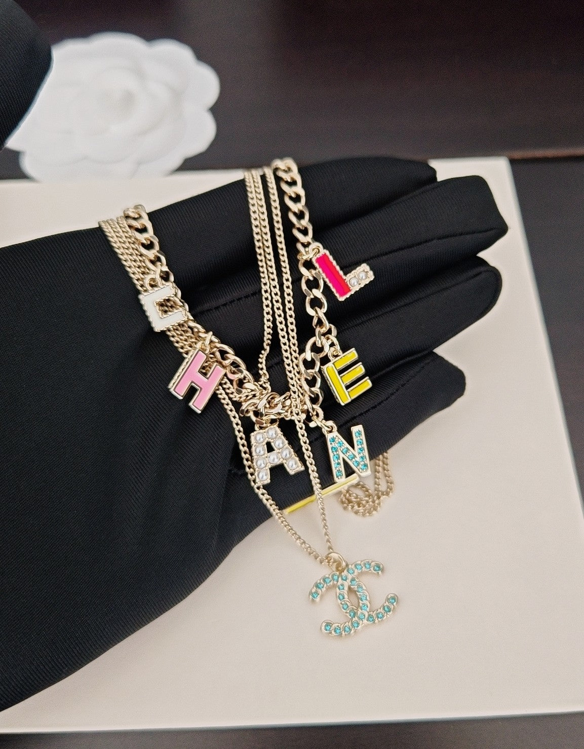 Gold-tone layered Chanel chain necklace with multicolor letter charms and CC pendant