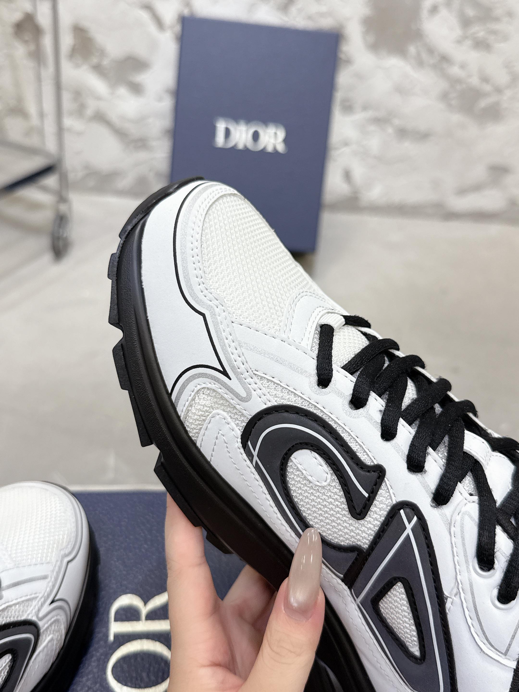 White Dior sneaker with black trim and lace-up, close-up side view