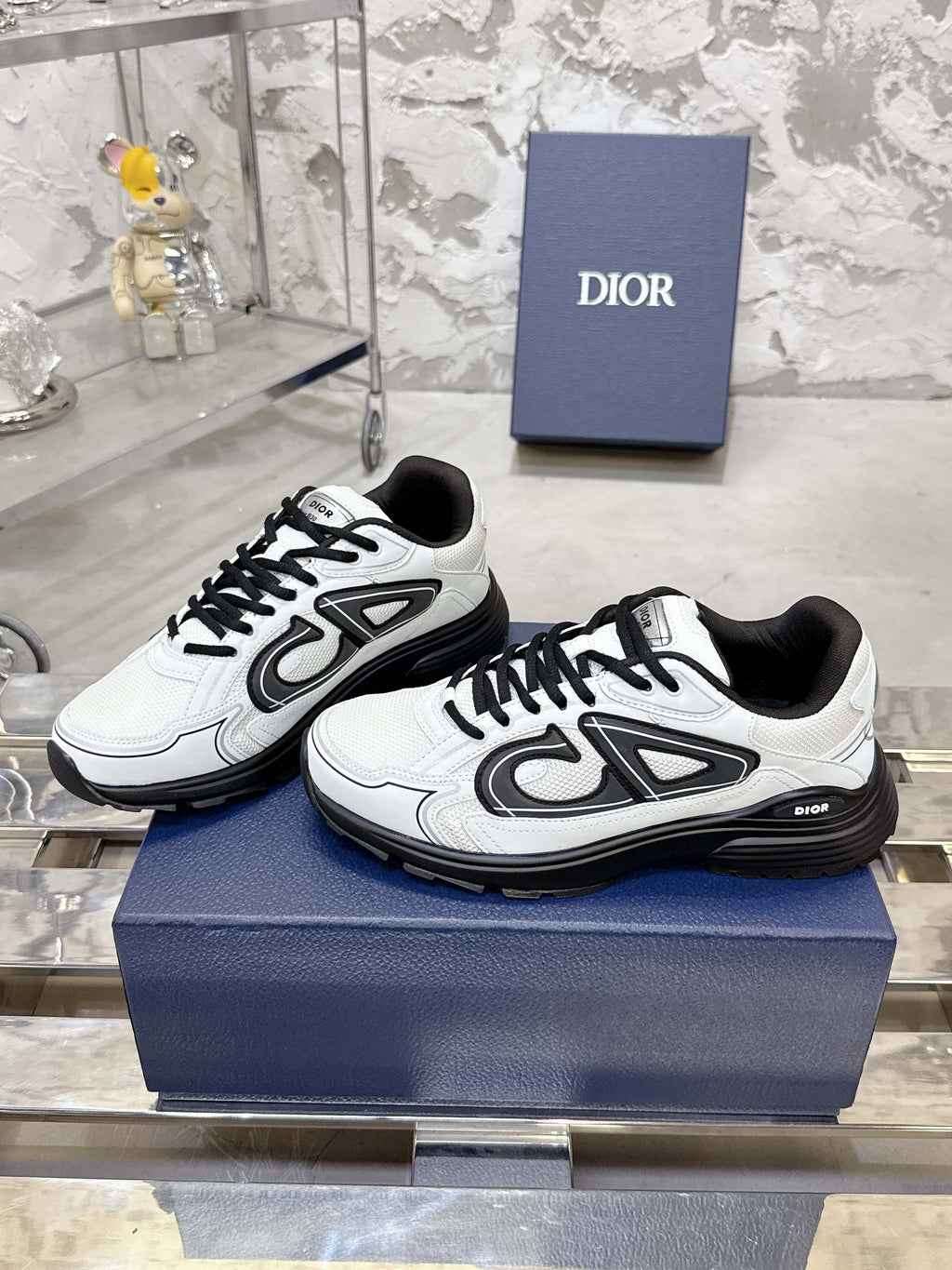 White Dior lace-up sneakers with black chunky sole, side view pair on box