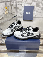 White Dior lace-up sneakers with black chunky sole, side view pair on box